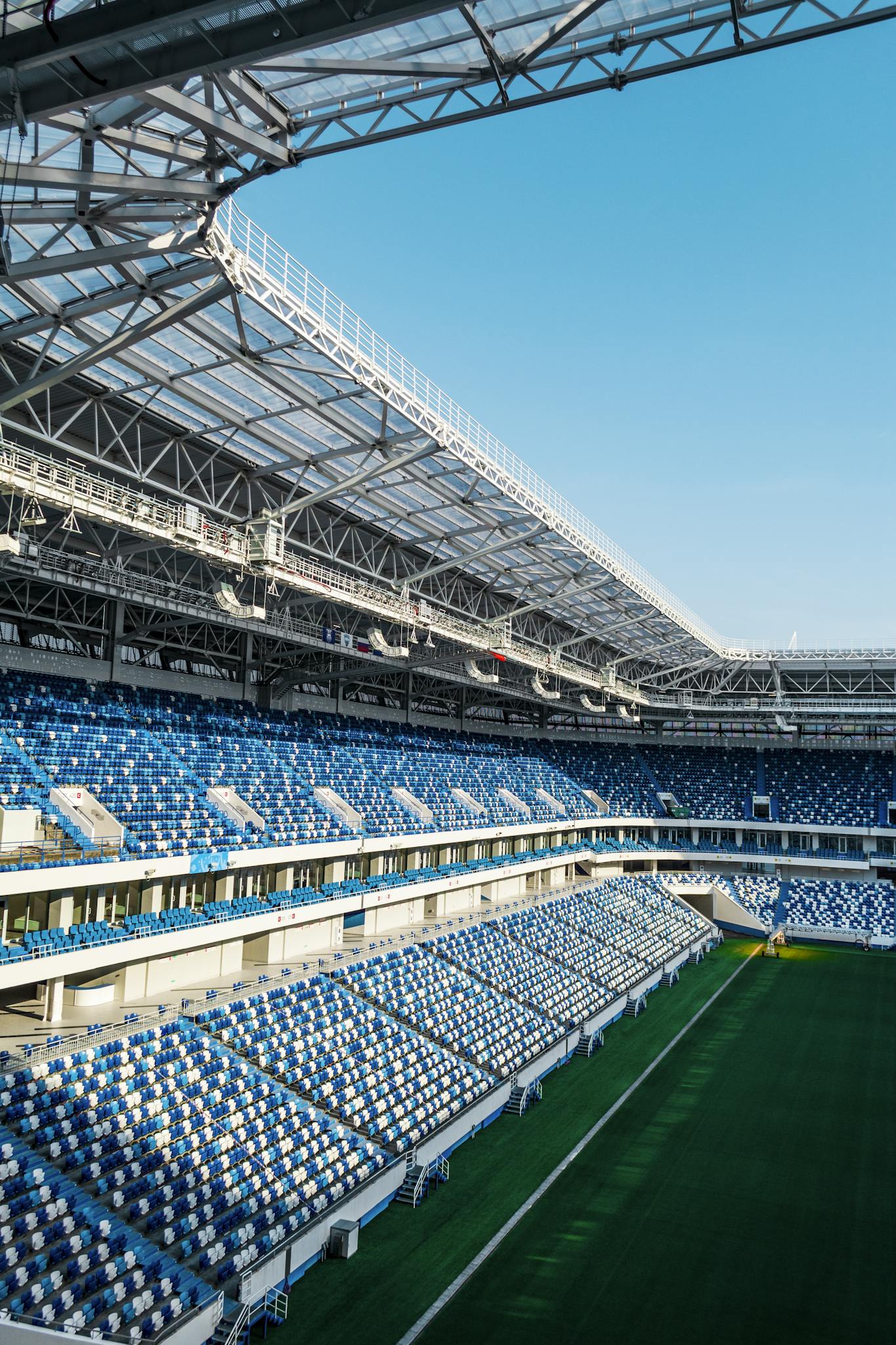 Spacious modern soccer stadium with blue seating and open sky view.